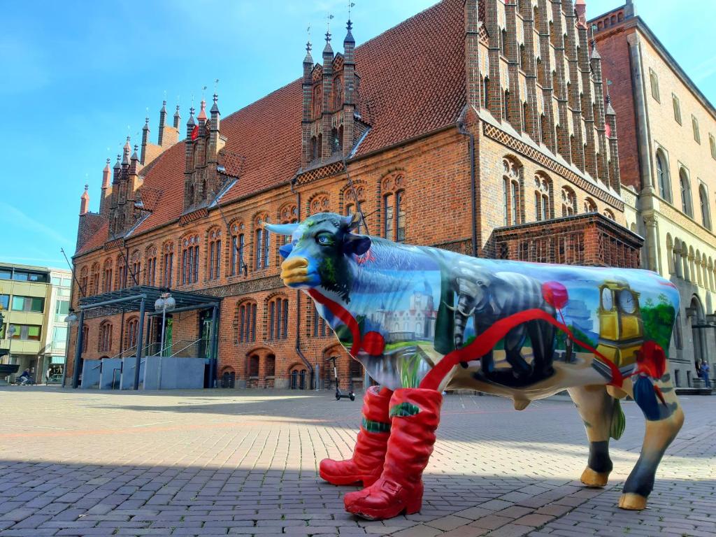 a statue of a cow standing in front of a building at Concorde Hotel am Leineschloss in Hannover