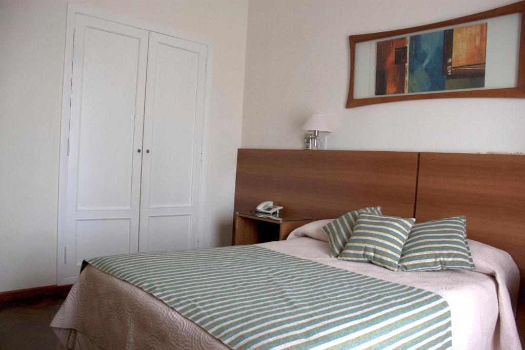 um quarto com uma cama com duas almofadas em Grand Hotel Rio Cuarto em Río Cuarto