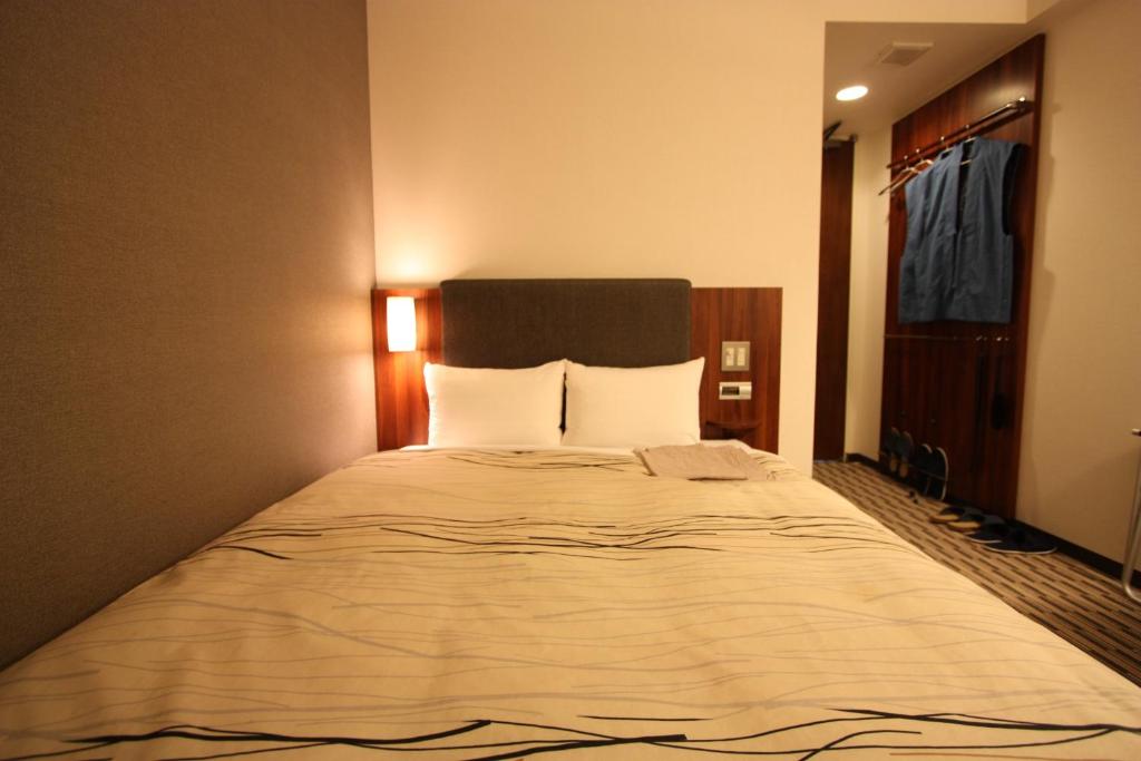 Postel nebo postele na pokoji v ubytování Uozu Manten Hotel Ekimae