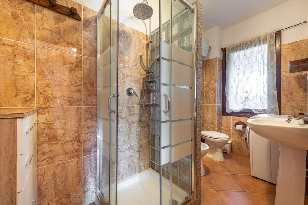 łazienka z prysznicem, toaletą i umywalką w obiekcie Villa Mallus 4 posti letto w mieście Olìa Speciosa