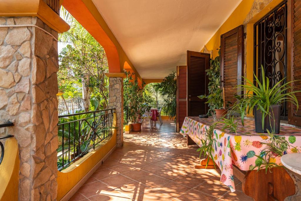 uma varanda de uma casa com plantas em Villa Mallus 4 posti letto em Olìa Speciosa