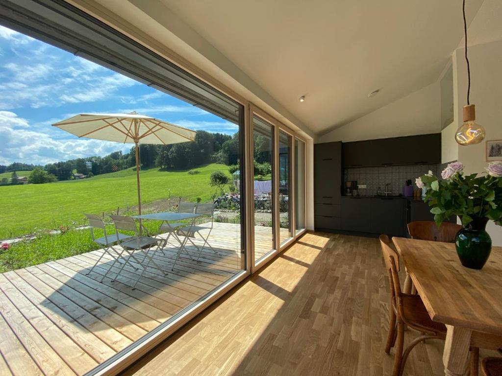 eine Küche und ein Esszimmer mit einem großen Glasfenster in der Unterkunft Guesthouse Paradies Samerberg in Samerberg