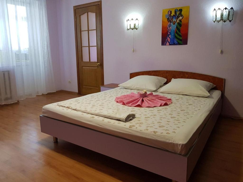 - un lit dans une chambre avec une robe rose dans l'établissement Апартаменты Нежная орхидея возле реки, à Mykolaïv
