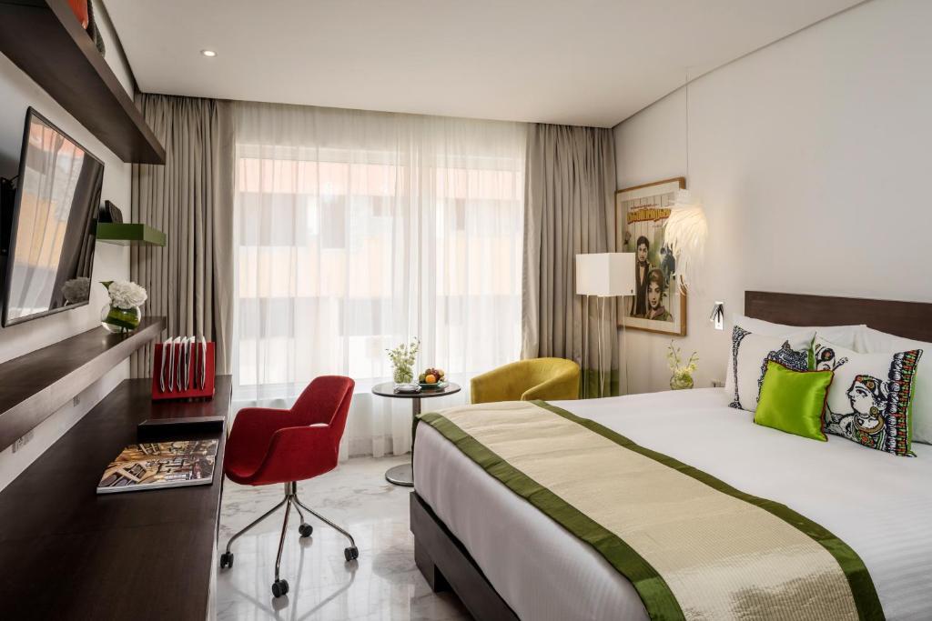 a hotel room with a large bed and a desk at The Park Chennai in Chennai
