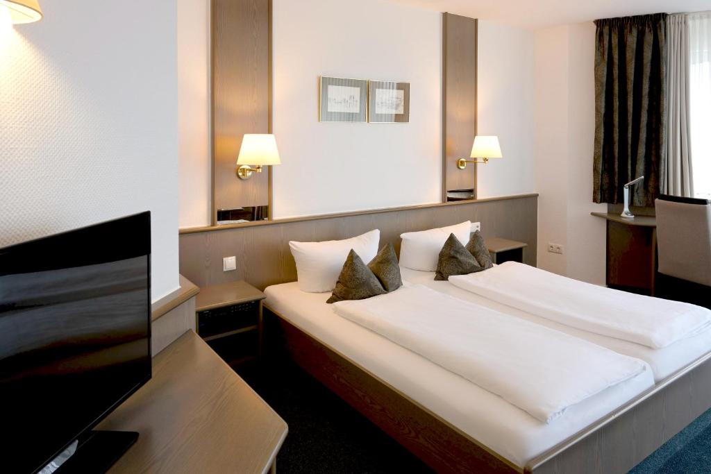 Postel nebo postele na pokoji v ubytování Hotel am Wasserfall