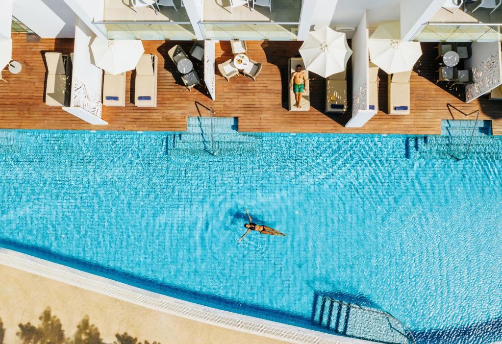 una persona nadando en una gran piscina en Sofianna Resort & Spa en Pafos