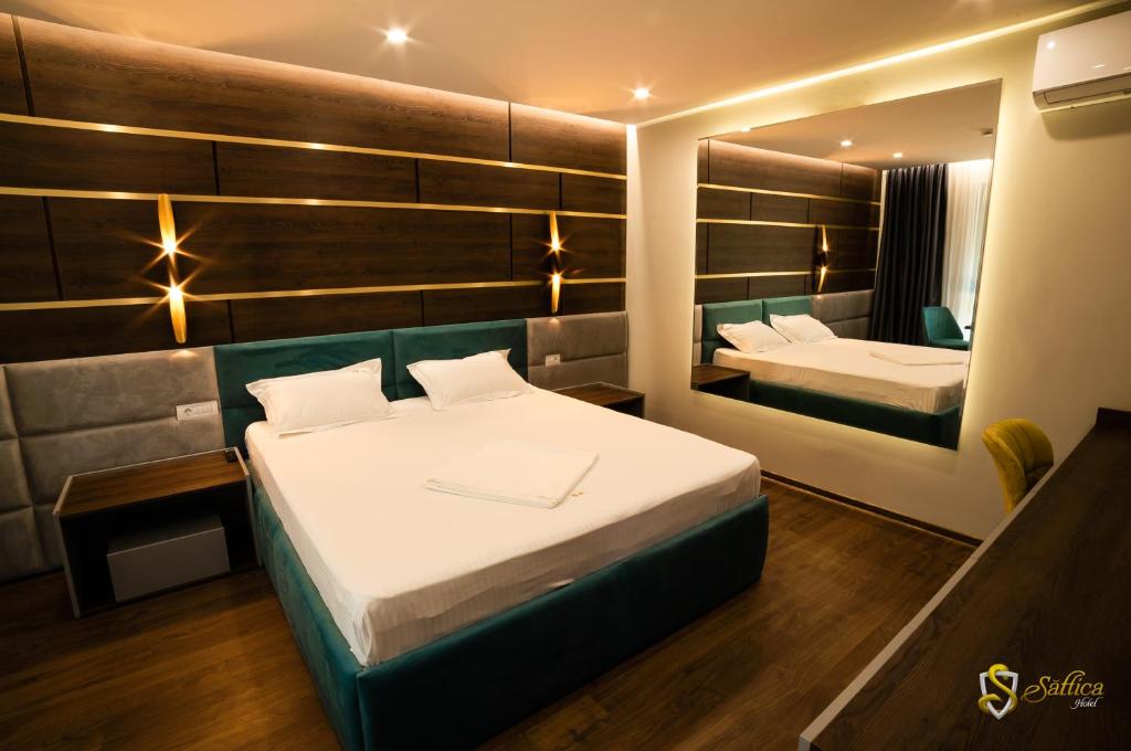una camera d'albergo con due letti e uno specchio di Hotel Saftica a Săftica