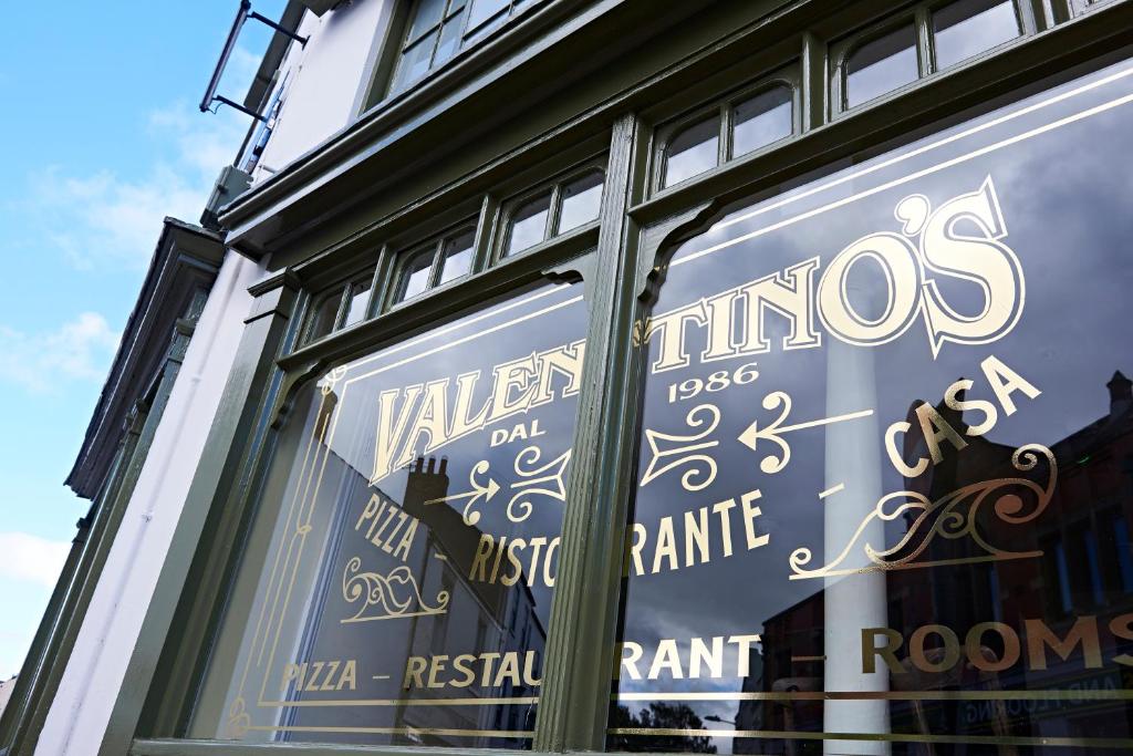 a window of a store with the words vilsos at Valentino s Restaurant with Rooms in Ripon