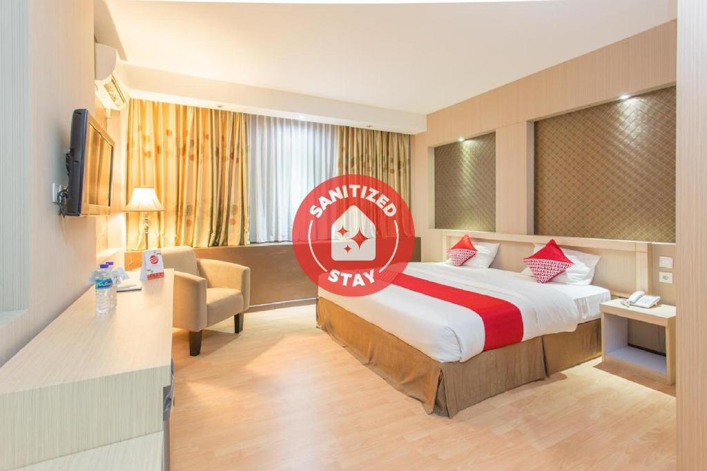 una habitación de hotel con una cama con un letrero rojo. en OYO 663 Hotel Sejati, en Balikpapan