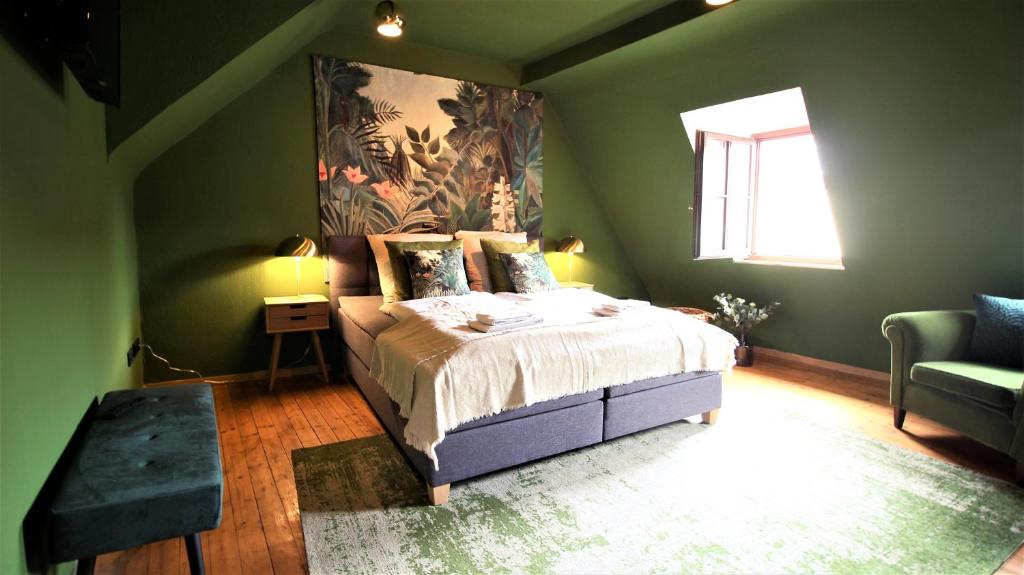een groene slaapkamer met een bed en een raam bij The George Rooms - Boutique Style in Würzburg