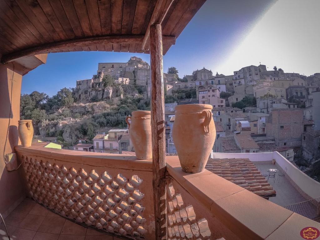 un balcón con dos jarrones sentados en la cornisa en Albergo Diffuso Borgo Santa Caterina "Quartire Hebraic", en Castiglione di Sicilia