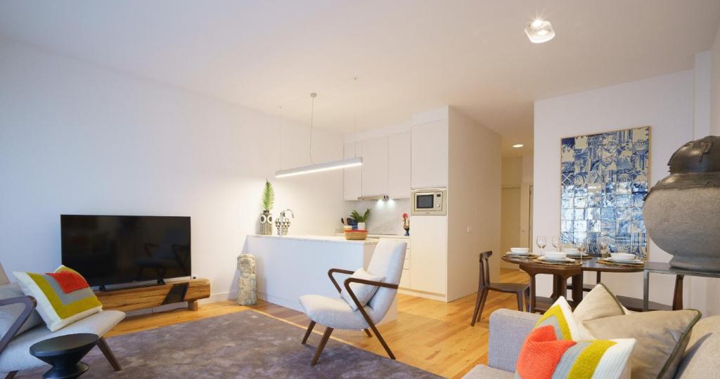 a living room with a couch and a tv and a kitchen at Stayin Apartments - Rua do Sol in Porto