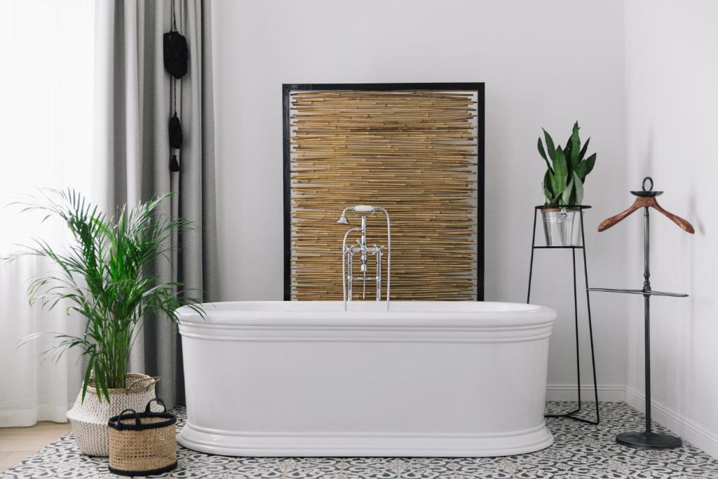 a white bath tub in a bathroom with plants at Bobritsa Dacha in Bobritsa