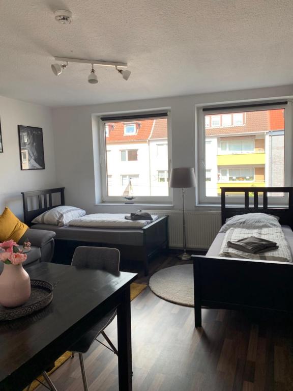 a living room with two beds and a table at City Studio Apartment in Bremerhaven