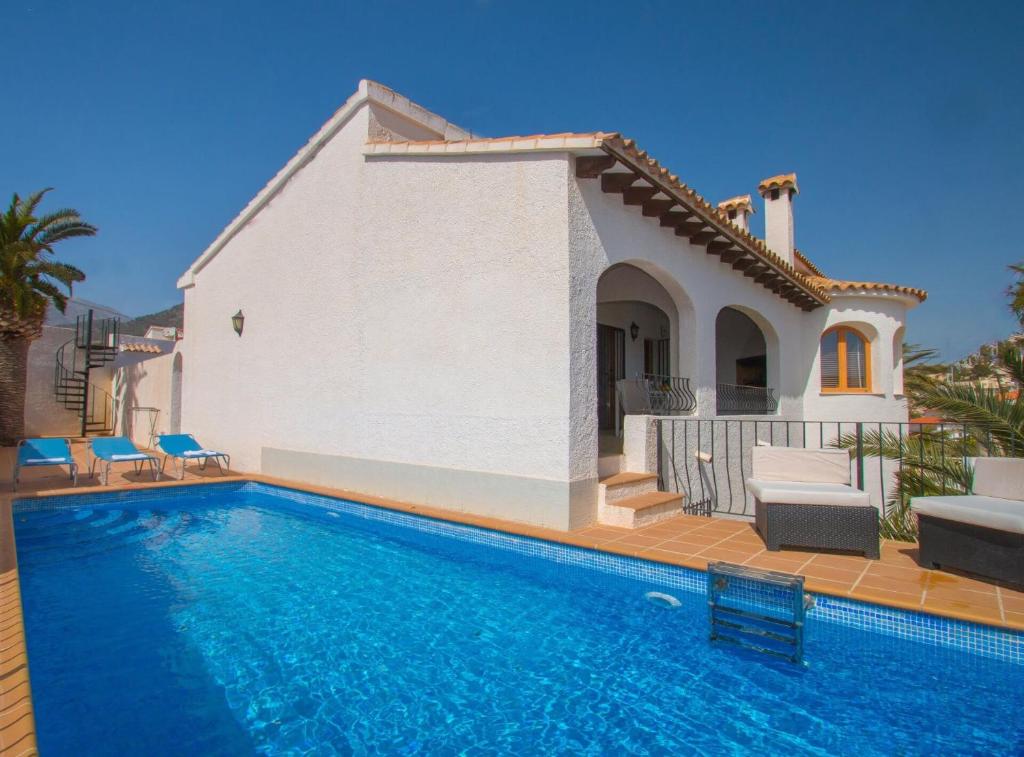 a villa with a swimming pool in front of a house at Villa Alexia - Plusholidays in Calpe