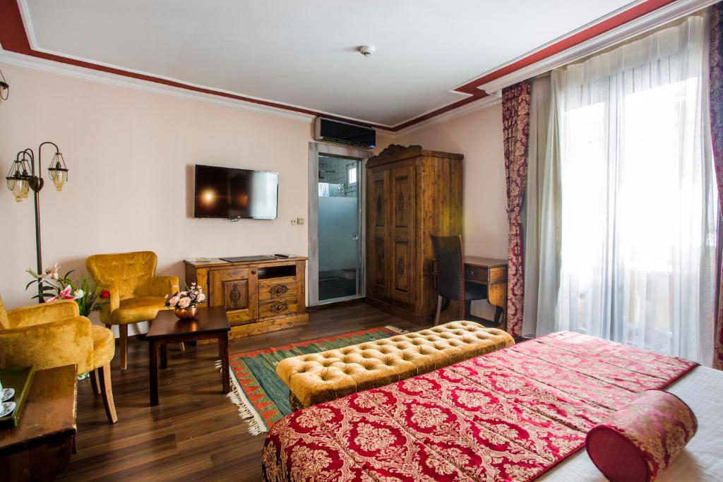 Un dormitorio con una cama grande y una sala de estar. en Garden House Hotel - Special Class, en Estambul