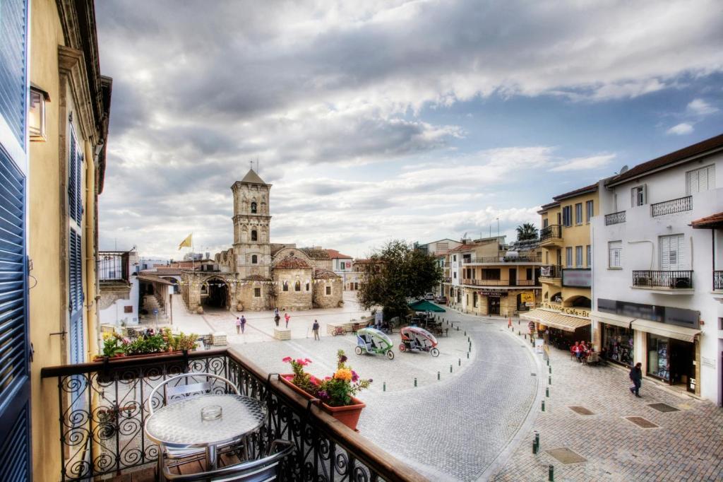 a view from a balcony of a town with a clock tower at Alkisti City Hotel in Larnaca