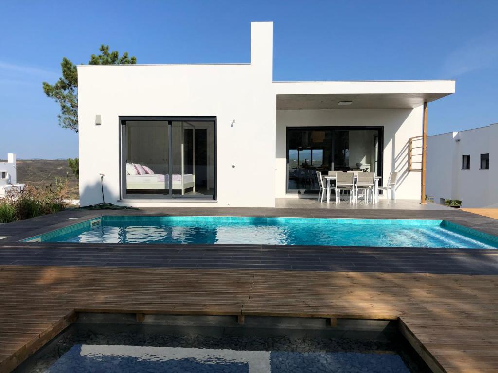 a villa with a swimming pool in front of a house at Cairnvillas - Villa Solar C37 Luxury Villa with Swimming Pool near Beach in Aljezur