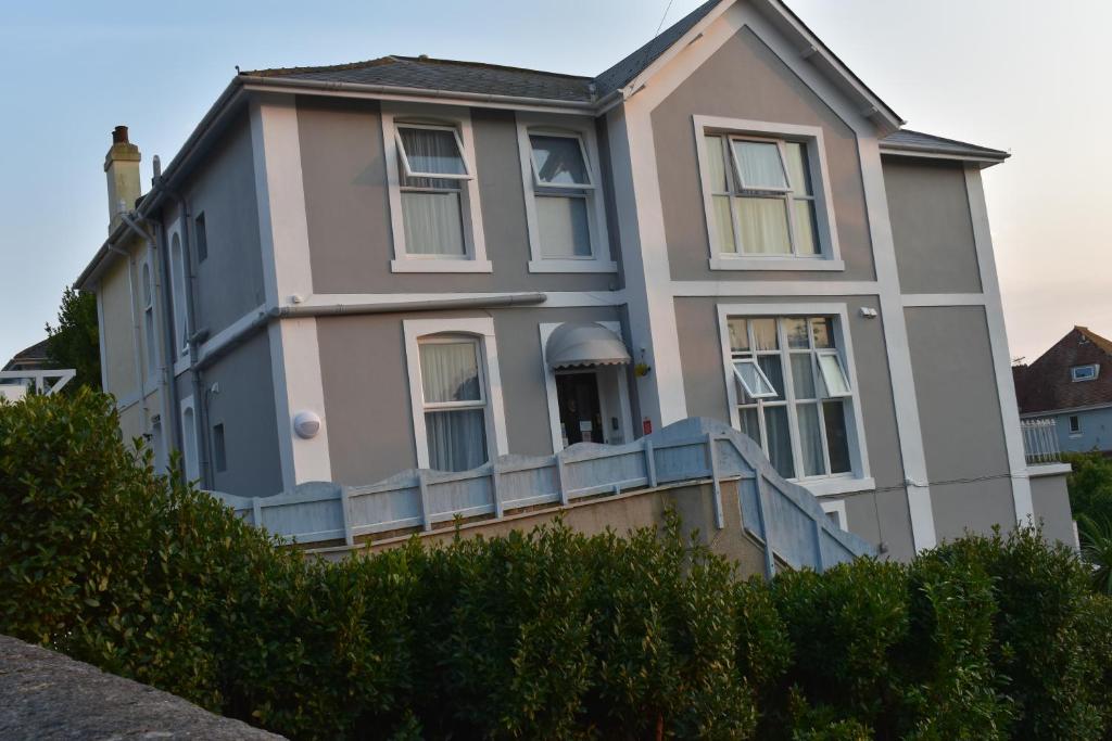 a house with a fence in front of it at Acorn Lodge in Torquay