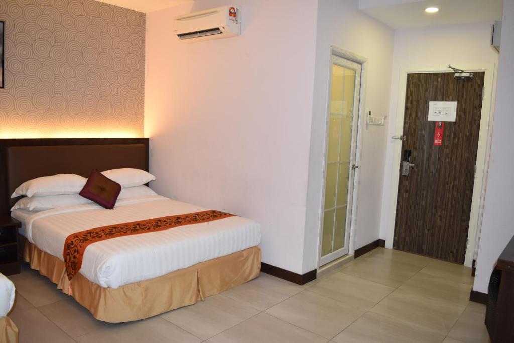 Un pat sau paturi într-o cameră la Sunrise Hotel