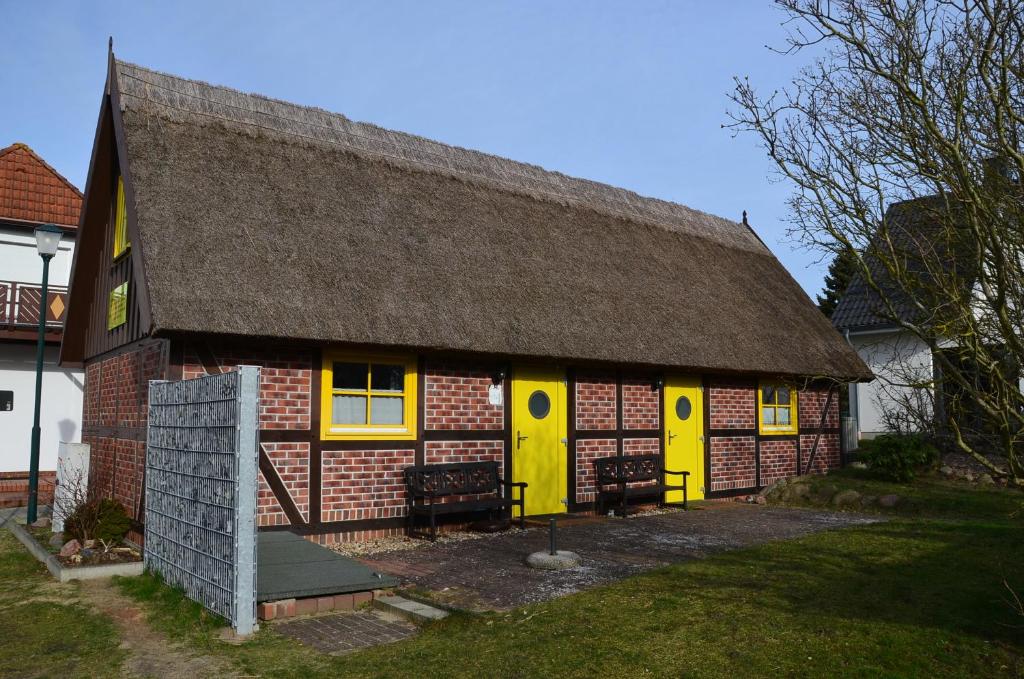 een klein gebouw met gele deuren en een dak bij Alte Scheune Koserow App. 1 in Ostseebad Koserow