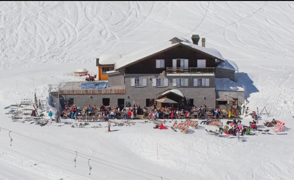 een groep mensen die buiten een skihut zitten bij Refuge Le Marcheuson in Les Crosets