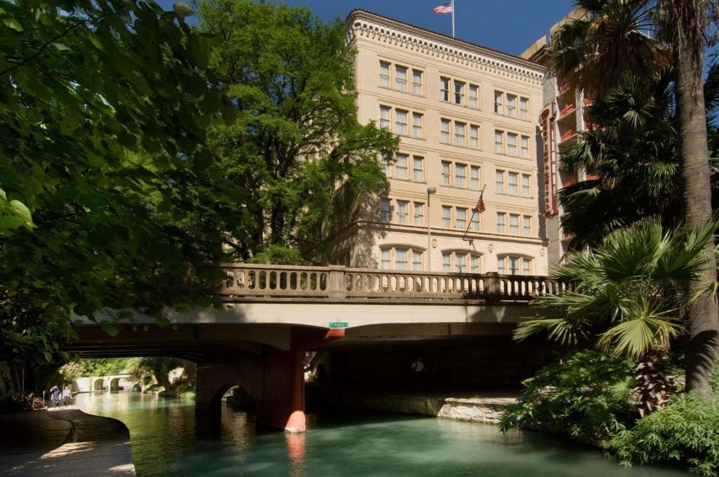 a bridge over a river in front of a building at Drury Inn & Suites San Antonio Riverwalk in San Antonio