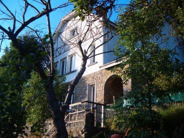 a large stone house with a large window at B&B Pittoresque in Houffalize