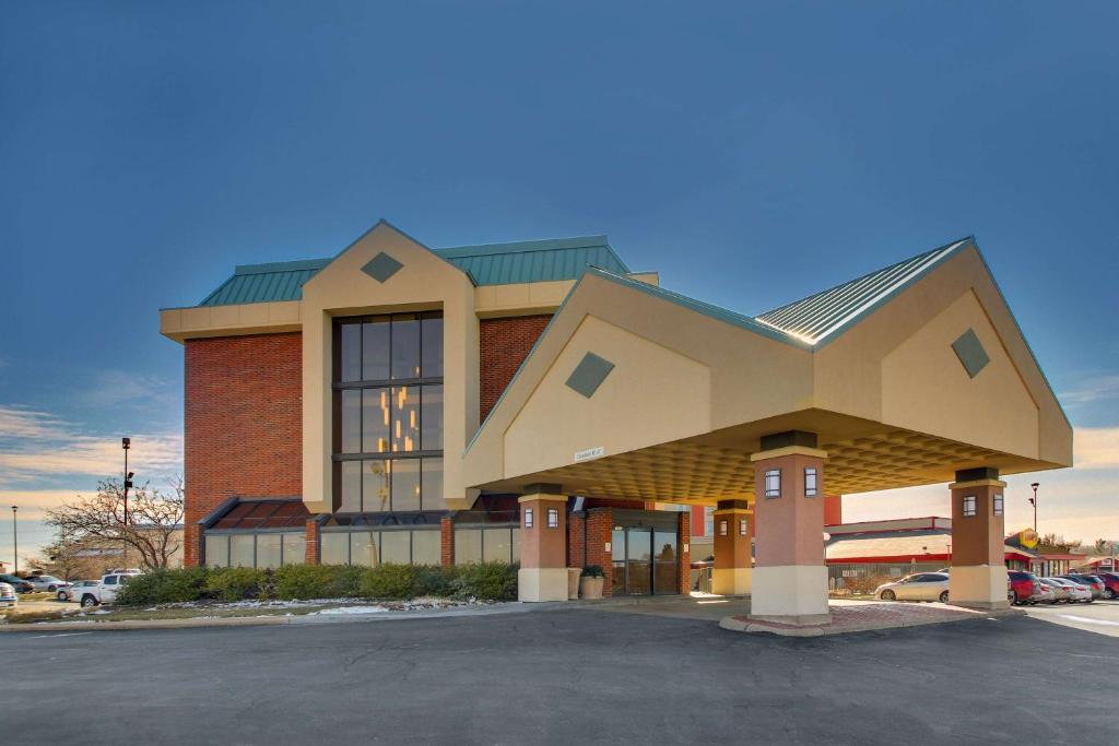 un grand bâtiment avec un toit en pierre dans un parking dans l'établissement Pear Tree Inn St. Louis - Arnold, à Arnold