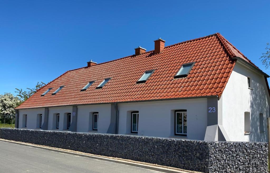ein weißes Gebäude mit rotem Dach auf einer Straße in der Unterkunft Ferienhaus Ostseekrabbe in Insel Poel