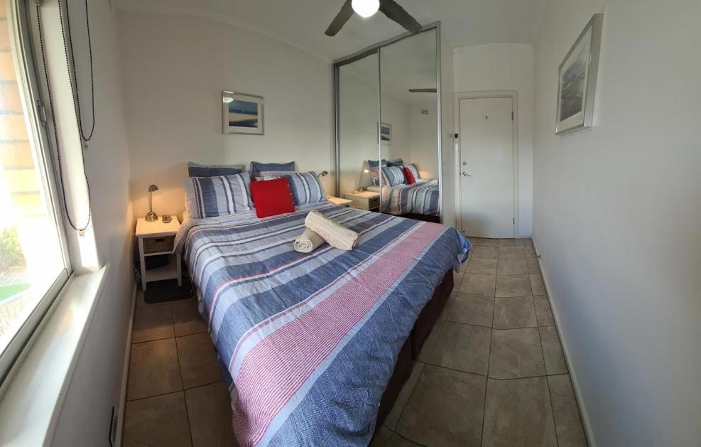 1 dormitorio con cama y ventana grande en Acushla Accommodation Esplanade Living Self Check-In Self Check-Out, en Adelaida