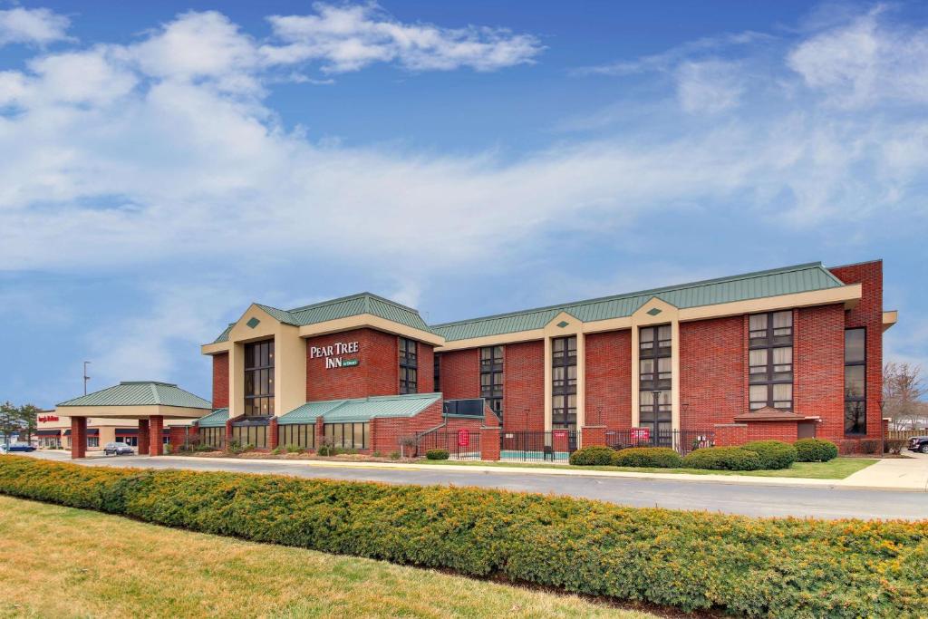 a large red brick building on a street at Best Western Plus Indianapolis North at Pyramids in Indianapolis