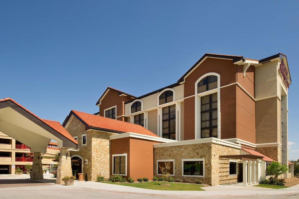 a large brick building with a building at Drury Plaza Hotel San Antonio Airport in San Antonio