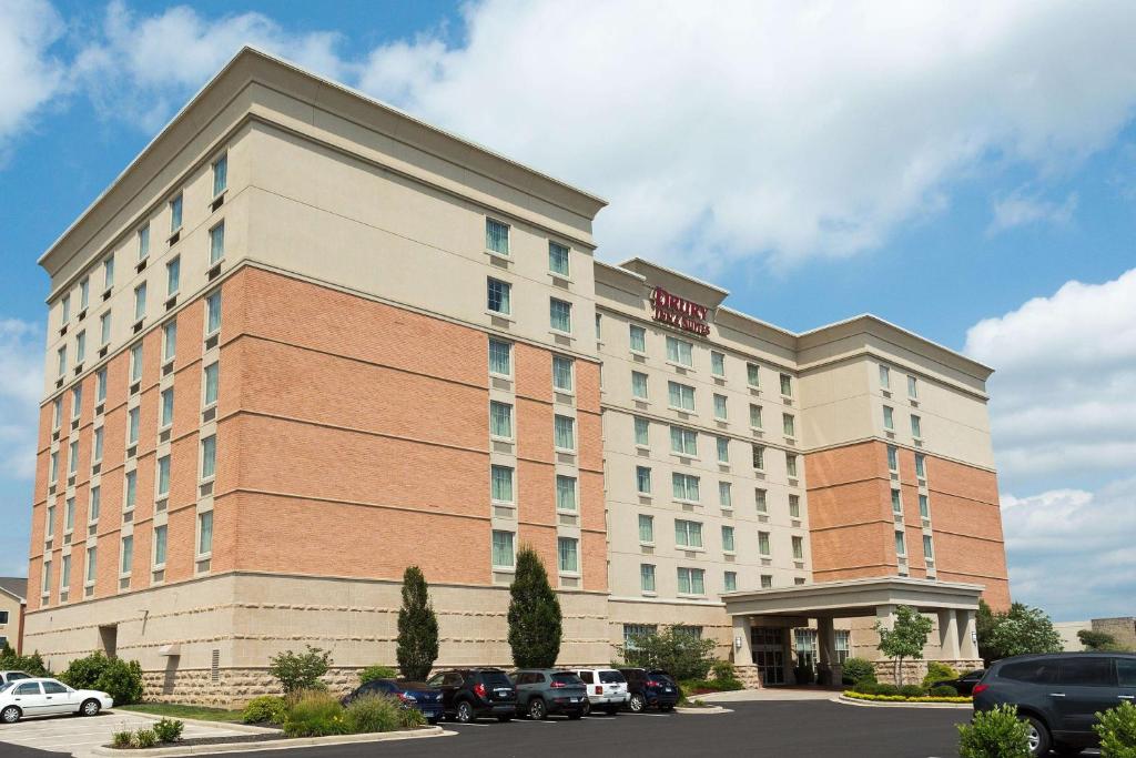 um edifício de hotel com carros estacionados num parque de estacionamento em Drury Inn & Suites Dayton North em Dayton