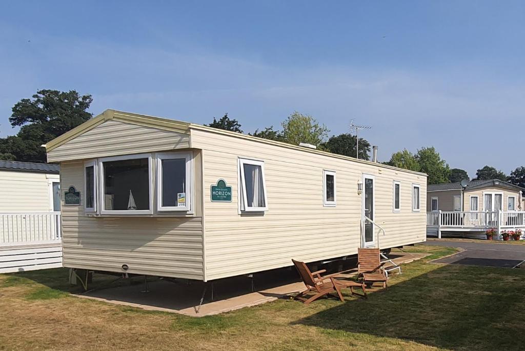 a mobile home with two chairs in a yard at The Wavering Knave in Starcross