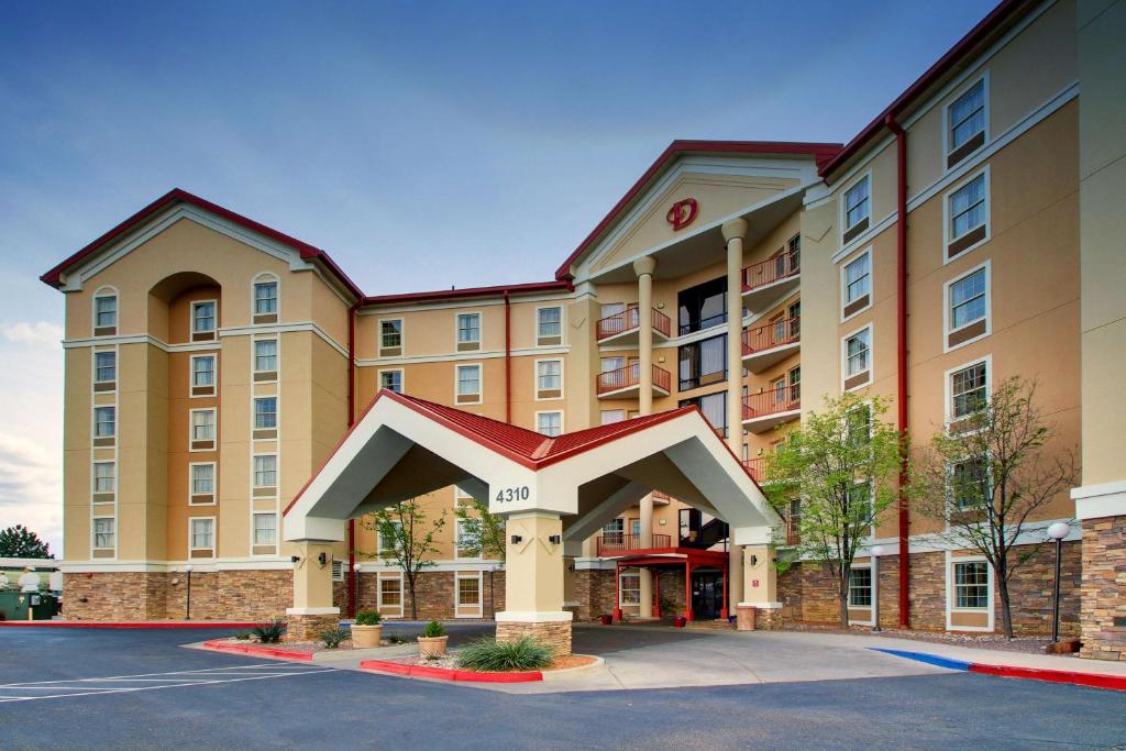 um hotel com um grande edifício com estacionamento em Drury Inn & Suites Albuquerque North em Albuquerque
