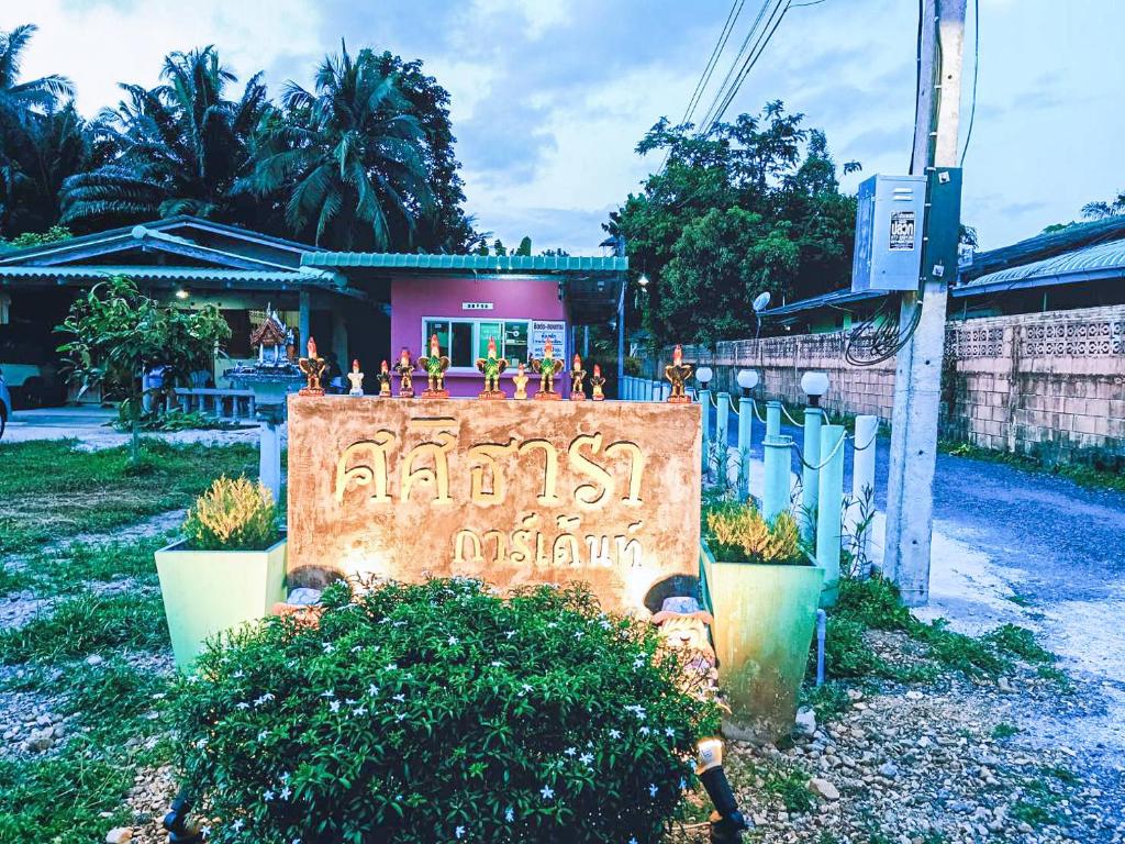 un panneau indiquant un restaurant devant un bâtiment dans l'établissement ศศิธารา การ์เด้นท์, à Sichon