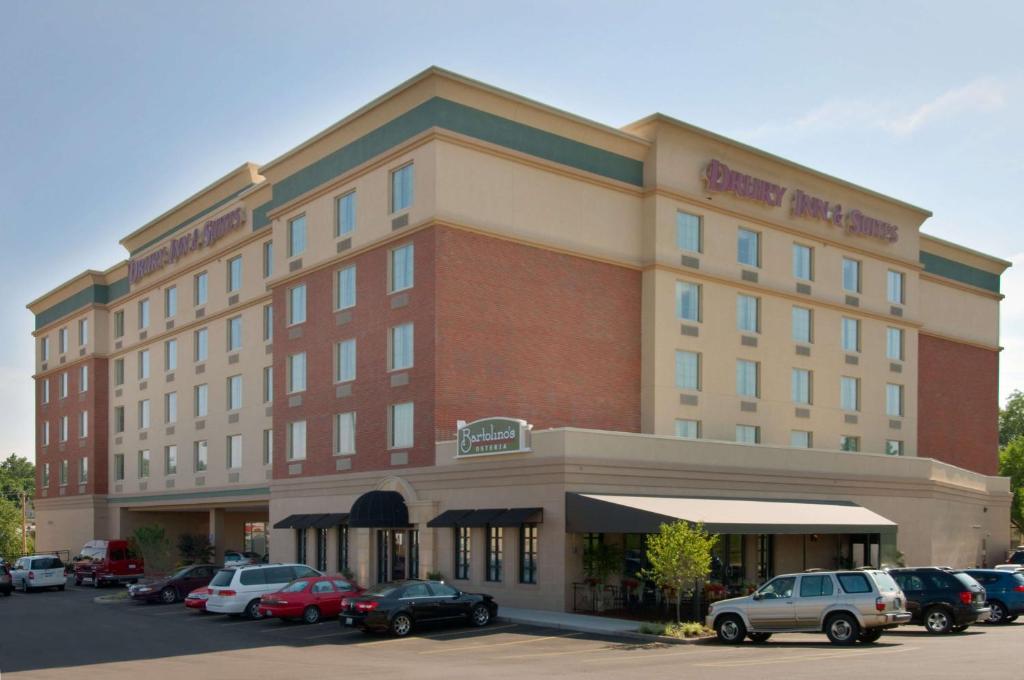 Drury Inn & Suites St. Louis Forest Park في سانت لويس: مبنى الفندق مع وجود سيارات تقف في موقف للسيارات