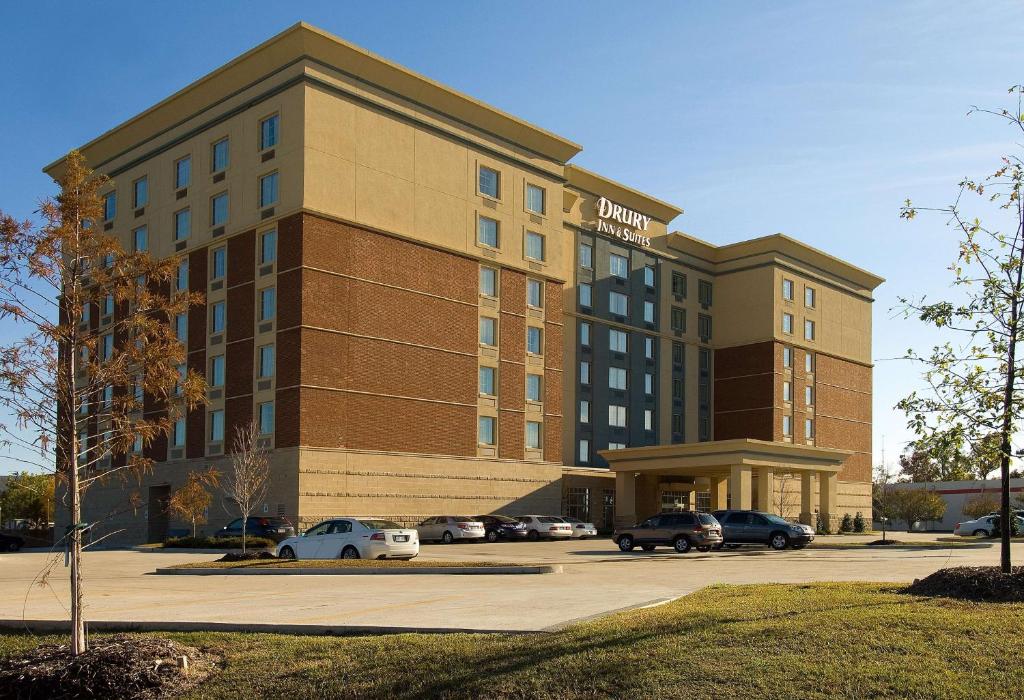 ein Hotelgebäude mit auf einem Parkplatz geparkt in der Unterkunft Drury Inn & Suites Baton Rouge in Baton Rouge