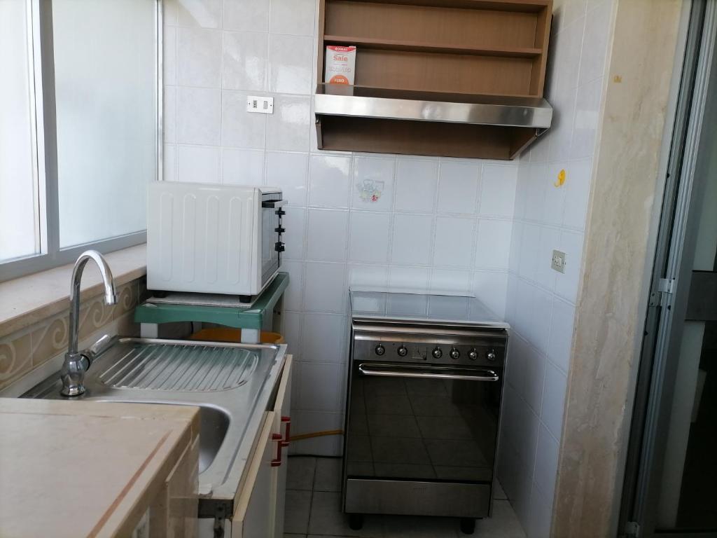 una piccola cucina con lavello e fornello di Alloggi Estivi D & A a Taranto