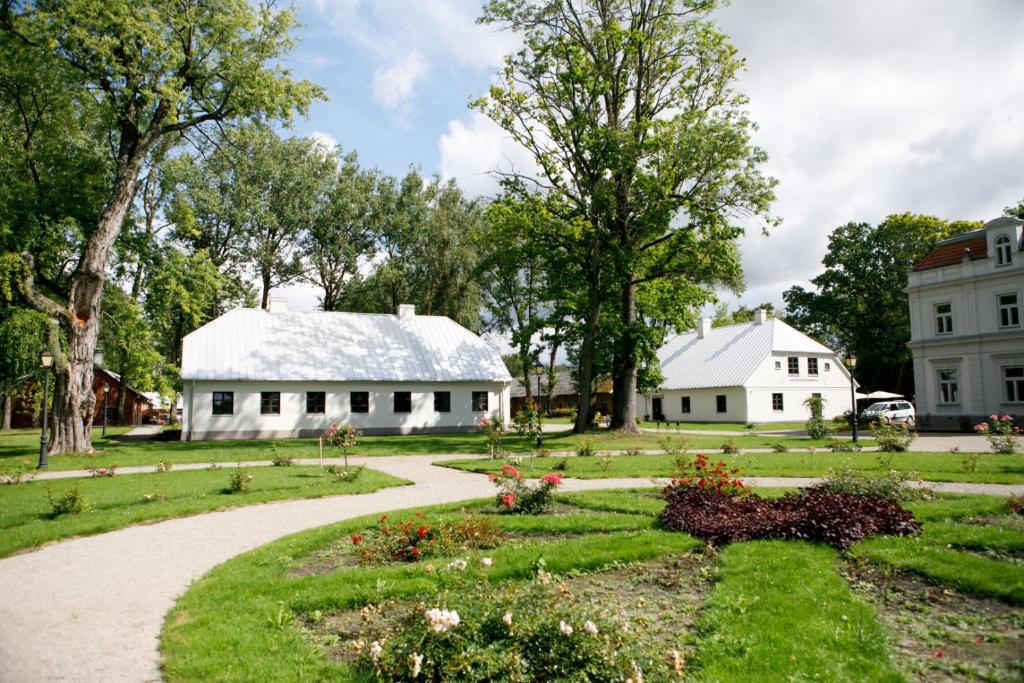 two white buildings with a garden and a house at Zyplių Dvaro Oficina Viešbutis 