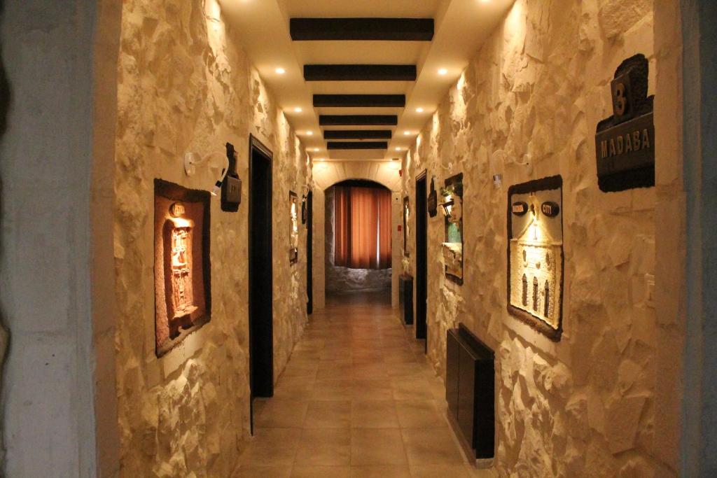 a hallway in a building with paintings on the walls at Mount Nebo Hotel & Restaurant Madaba City Center in Madaba