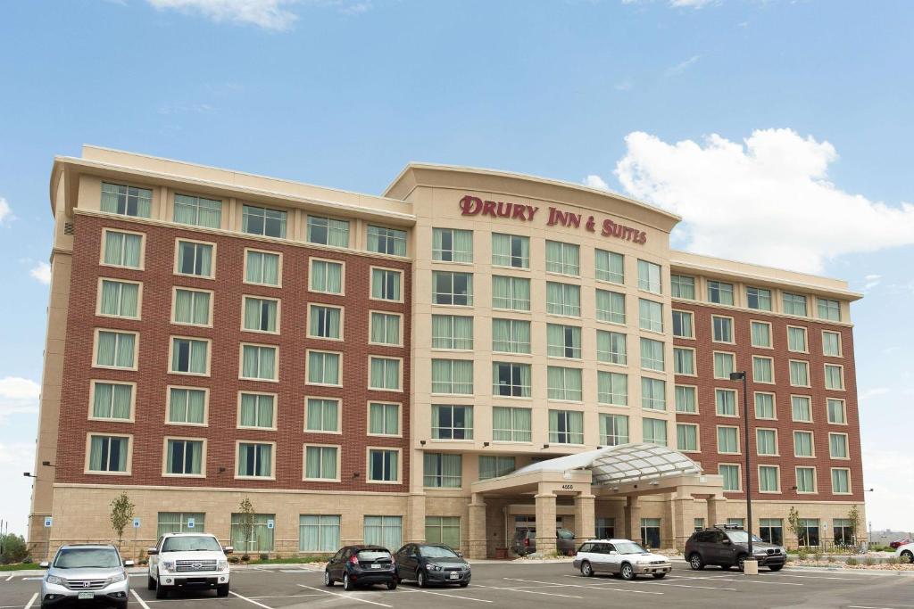 un gran edificio con coches estacionados en un estacionamiento en Drury Inn and Suites Denver Central Park, en Denver