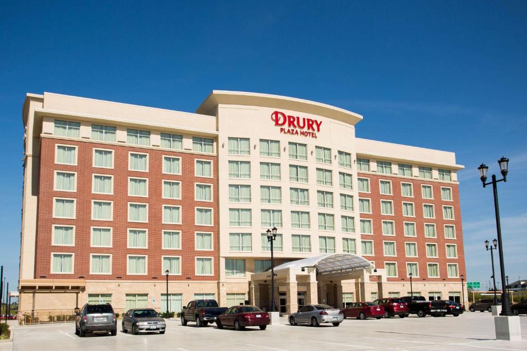 a hotel building with cars parked in a parking lot at Drury Plaza Hotel St. Louis St. Charles in St. Charles