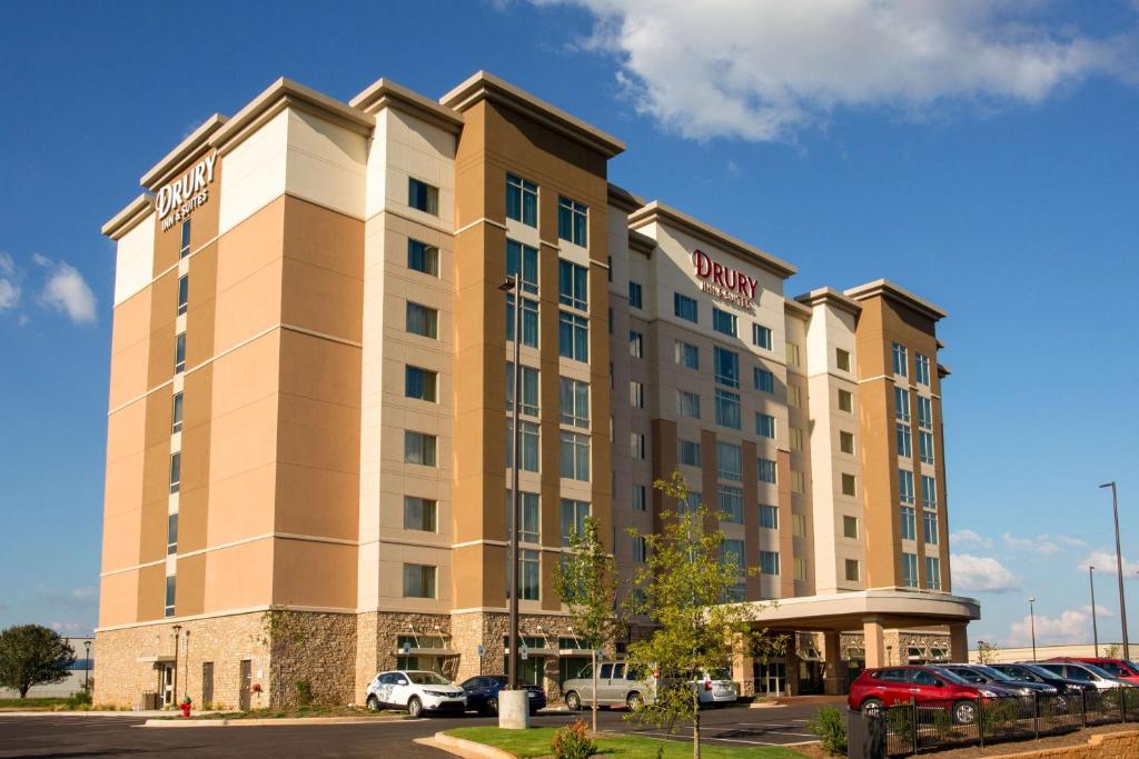 Drury Inn & Suites Huntsville Space & Rocket Center في هانتسفيل: مبنى الفندق مع وجود سيارات تقف في موقف للسيارات