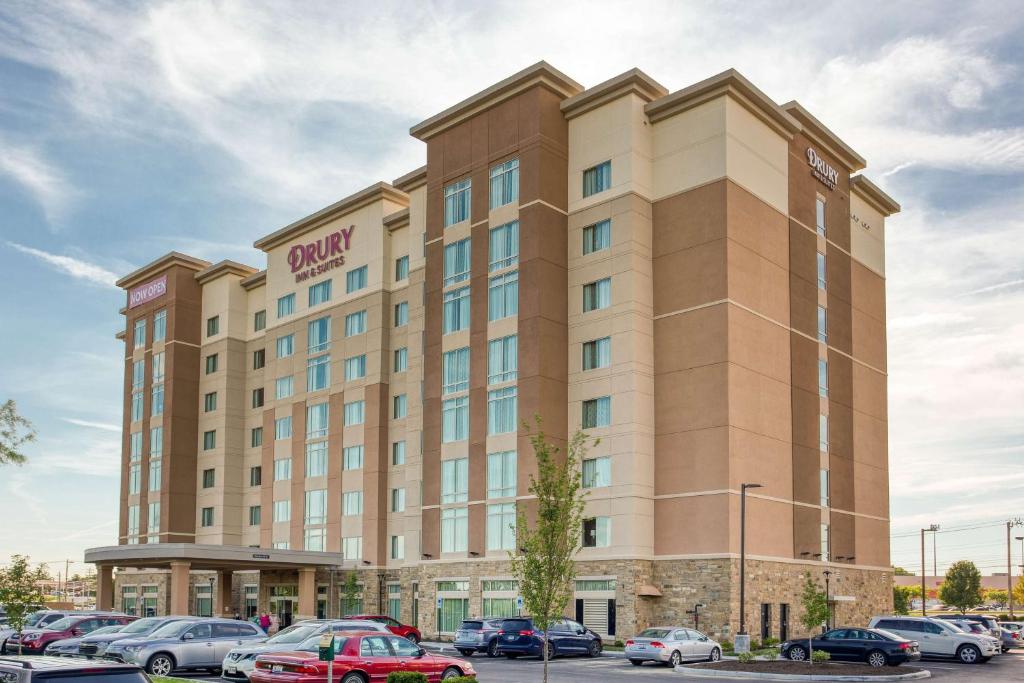 梅森的住宿－Drury Inn & Suites Cincinnati Northeast Mason，停车场内停放汽车的酒店大楼