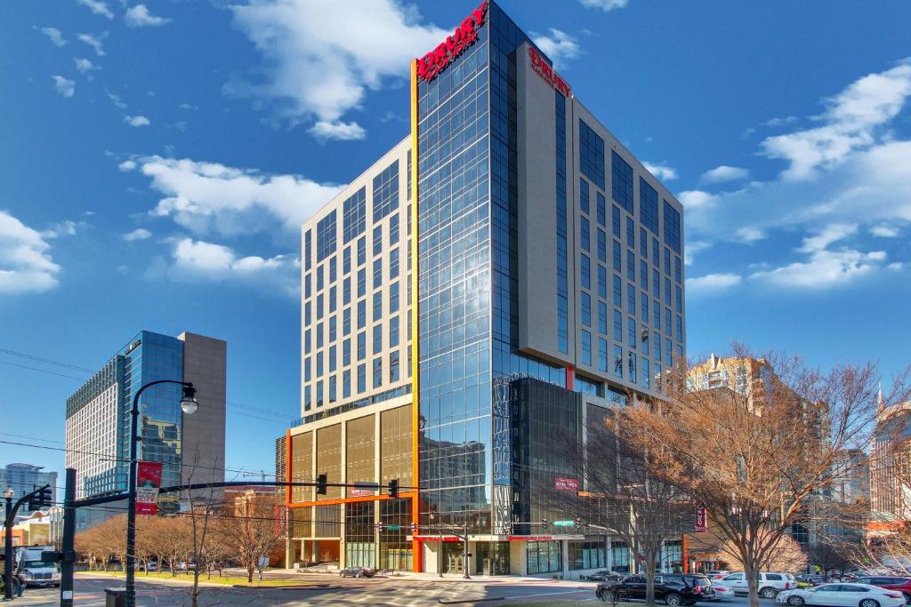 ein hohes Glasgebäude mit einem roten Schild darauf in der Unterkunft Drury Plaza Hotel Nashville Downtown in Nashville