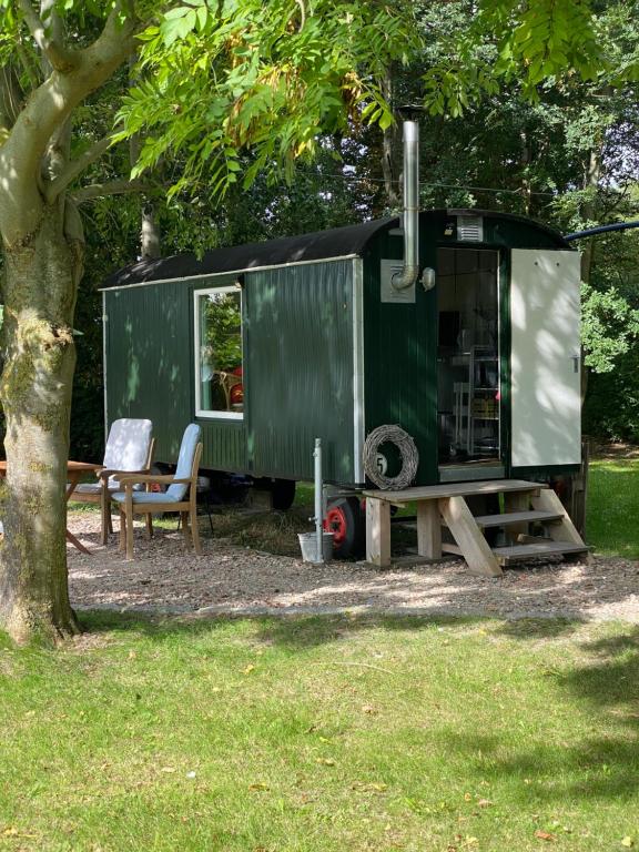 a green trailer parked next to a tree at Gut Groß Fedderwarden in Butjadingen