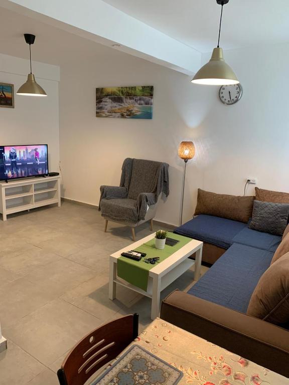 a living room with a couch and a table and a tv at EXCLUSIVE COMFORT PREMIUM in Beer Sheva