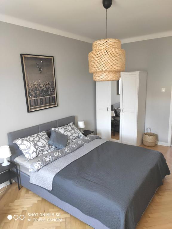 a bedroom with a bed and a pendant light at Apartament przy Zamku in Lublin